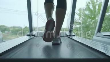 女人<strong>肌</strong>肉发达的腿在健身房<strong>跑步机</strong>上，特写。